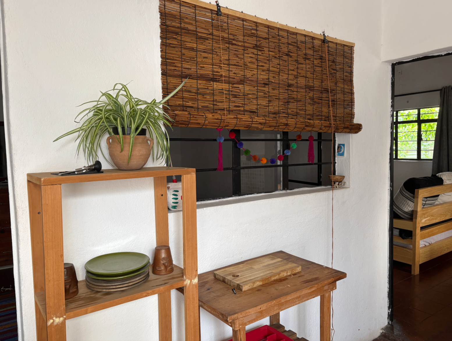 Kitchen nook with wood shelving and bamboo shade.